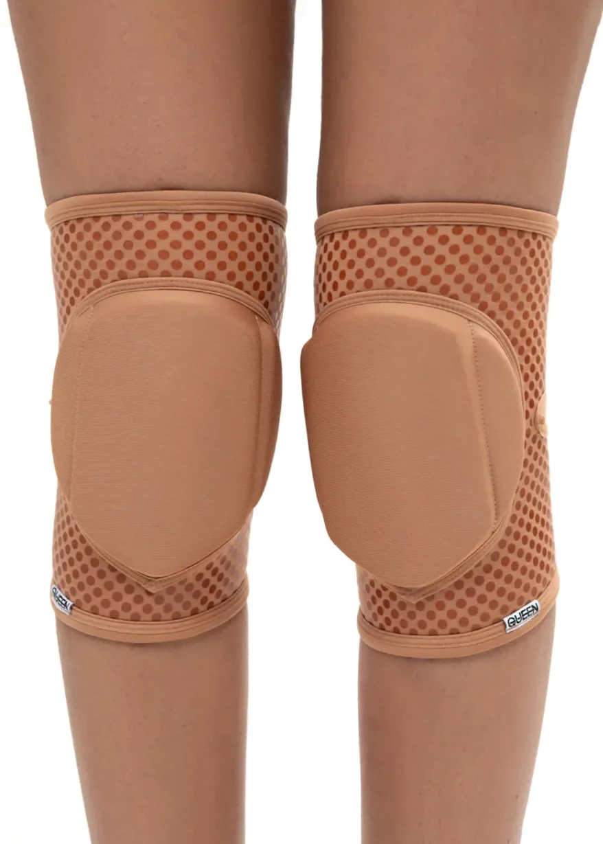 IMG_5909 Pair of peach knee protectors with hard caps and dotted fabric, shown from behind on the legs.
