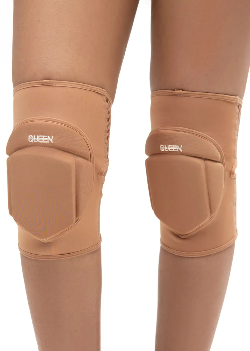 IMG_5942 Tan knee braces worn on both knees with padded protective guards and strap closures, showing the brand name QUEEN on each pad.