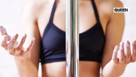 Sweaty Hands on the Pole Grip Aids That Actually Work Pole dancer in a black sports bra with chalky hands gripping a vertical chrome pole.