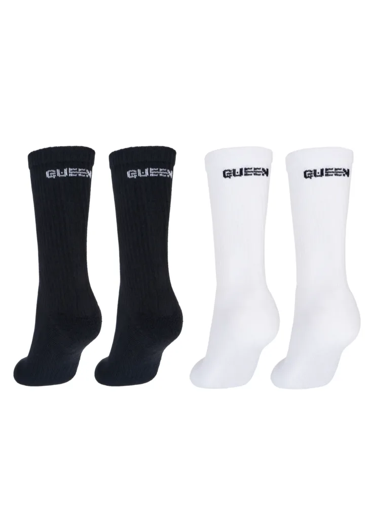 image Four socks arranged in two black socks on the left and two white socks on the right, with GUESS branding on the cuffs.